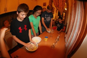 The kids combining the eggs with Semolina flour. Notice all our ravioli cutters :-)