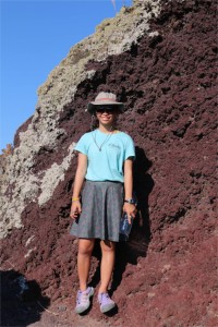Yve next to the rich, red volcanic dirt